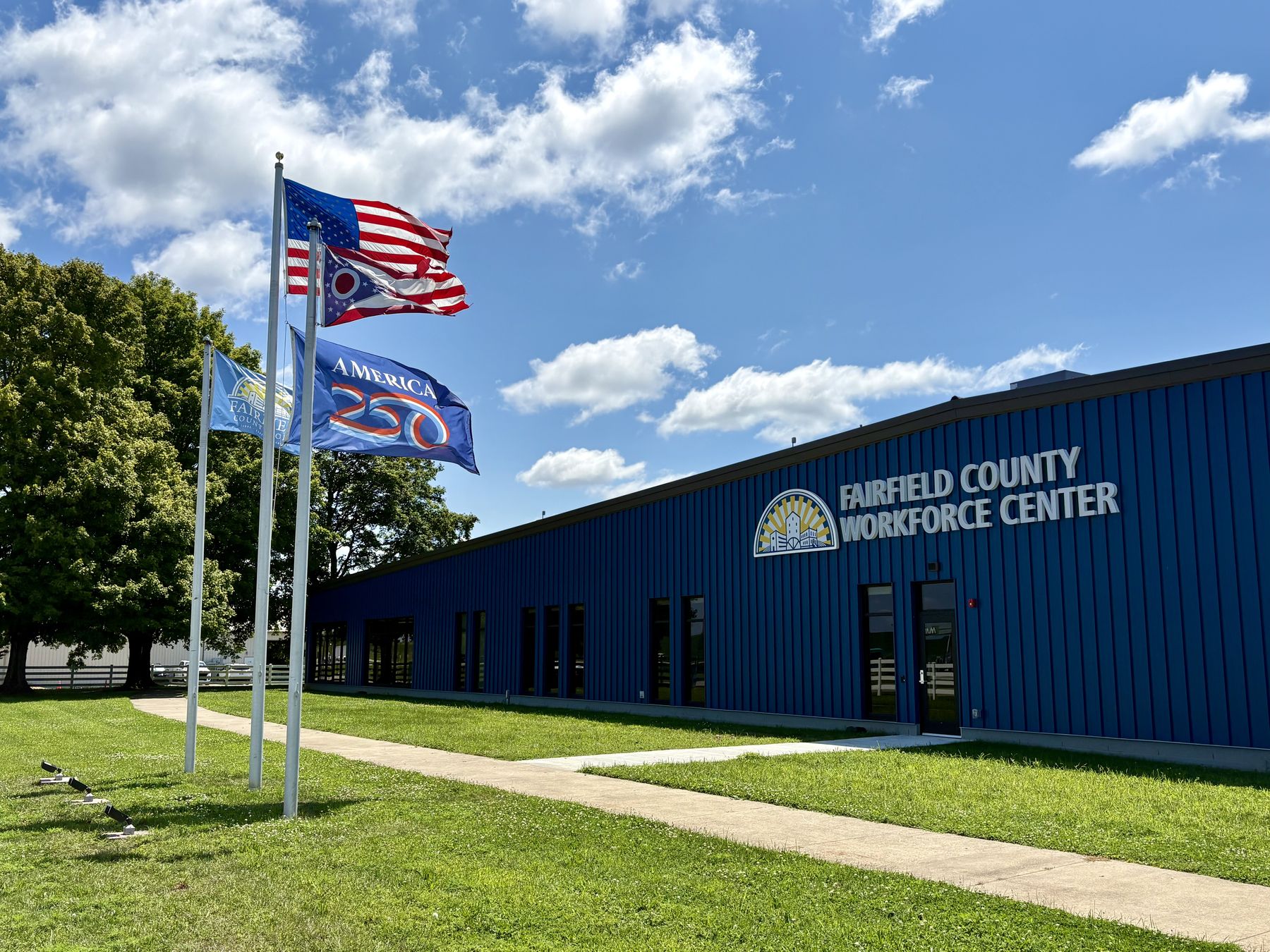 The Fairfield County Workforce Center building in Carroll, Ohio, with United States, Ohio, and Fairfield County flags flying out front.