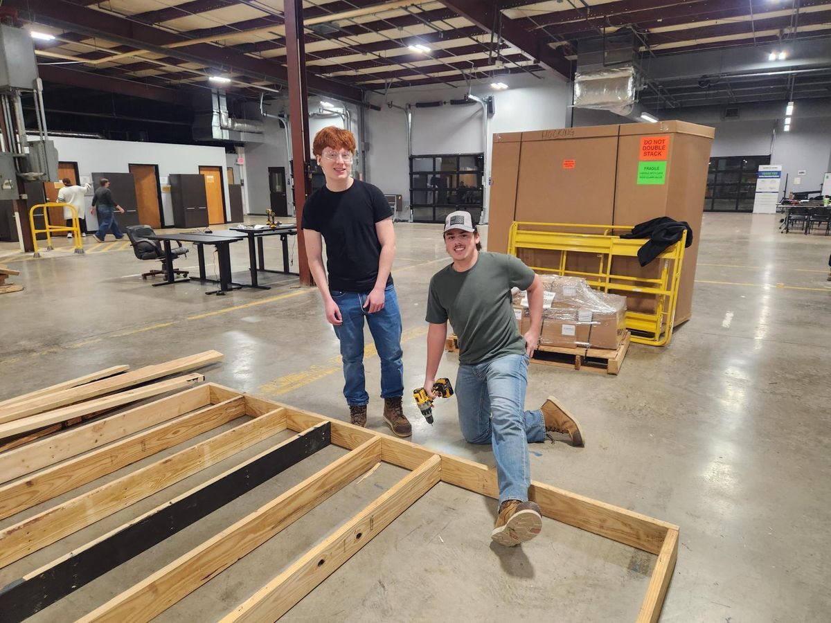 Two pre-apprenticeship students framing a wall in the training bay.